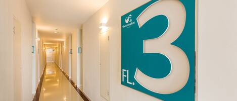 A hallway with a teal sign indicating room number 3.