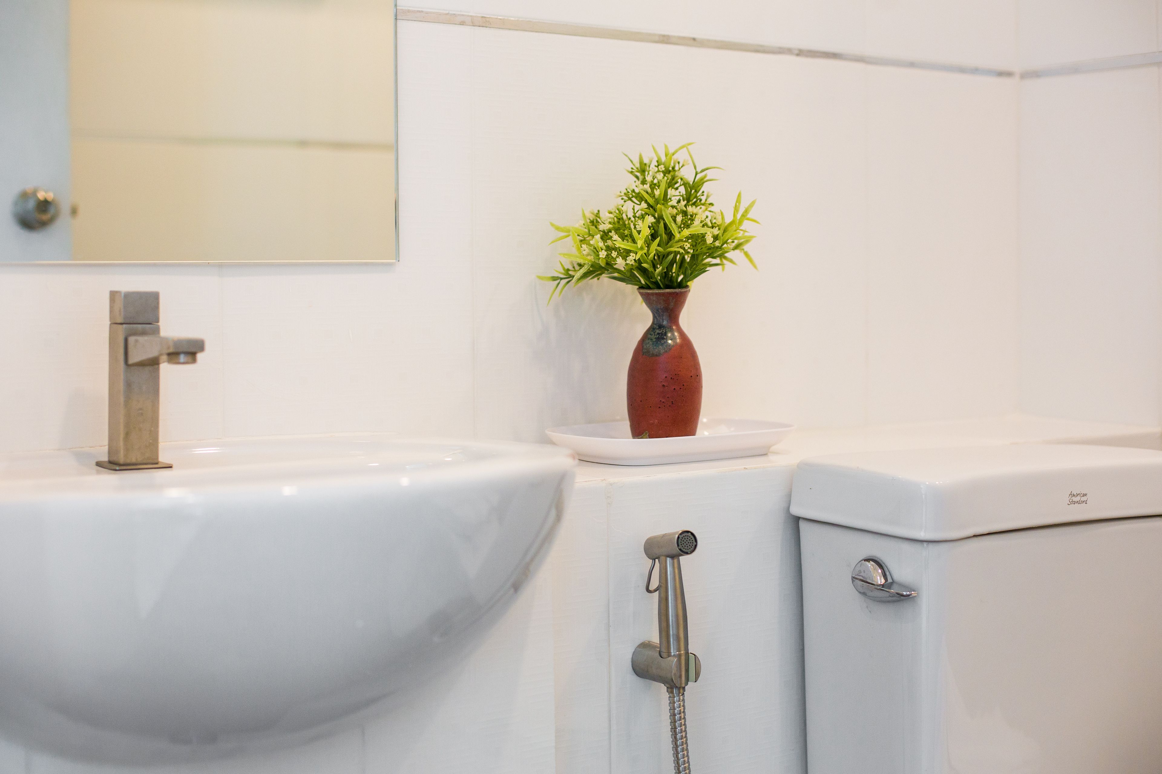 Een badkamer met een wit wastafel, een spiegel en een toilet.