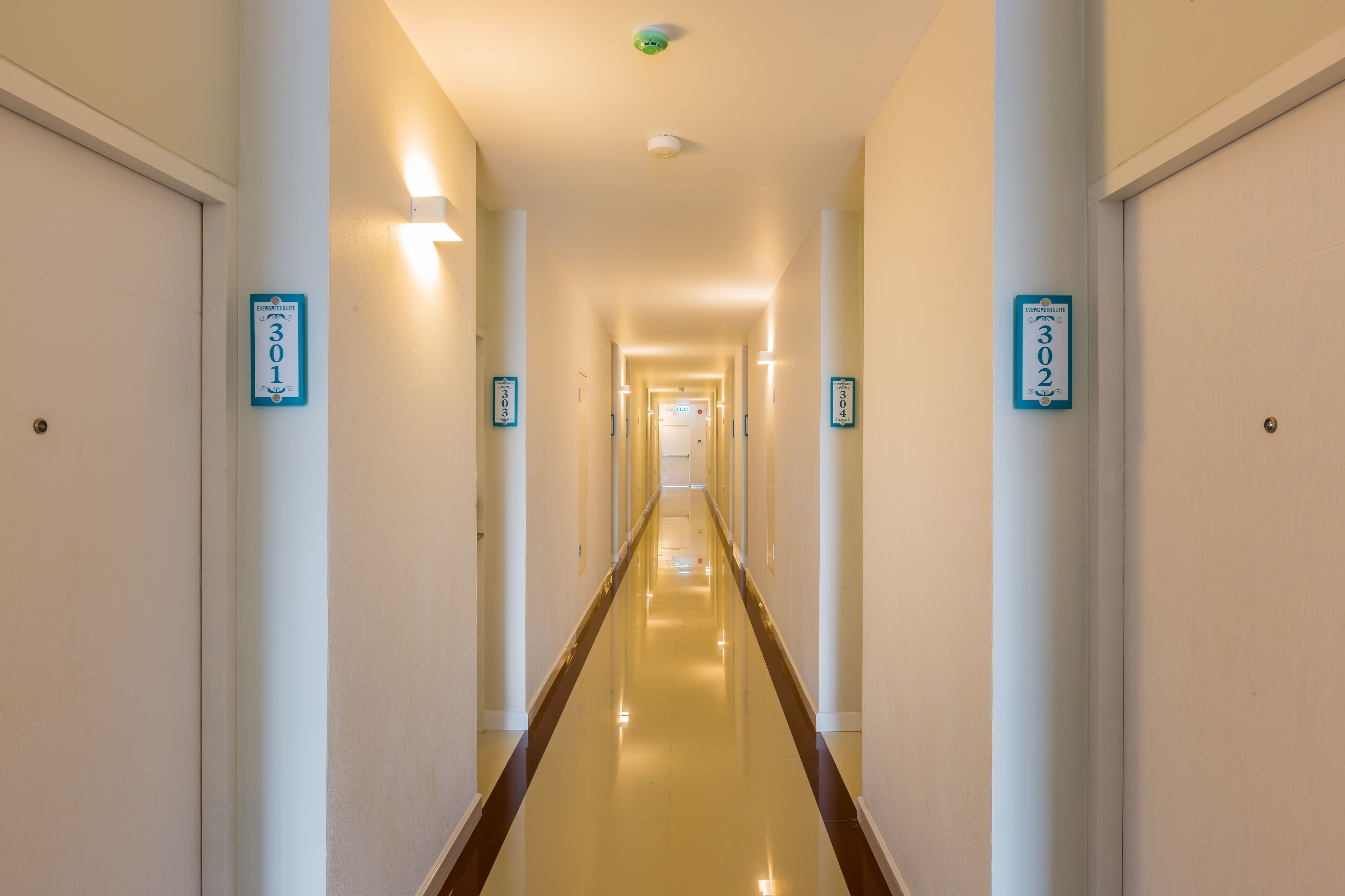 A long, well-lit hallway with doors numbered 301 and 302.