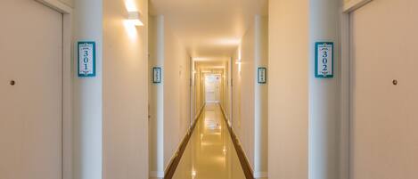 A long, well-lit hallway with doors numbered 301 and 302.