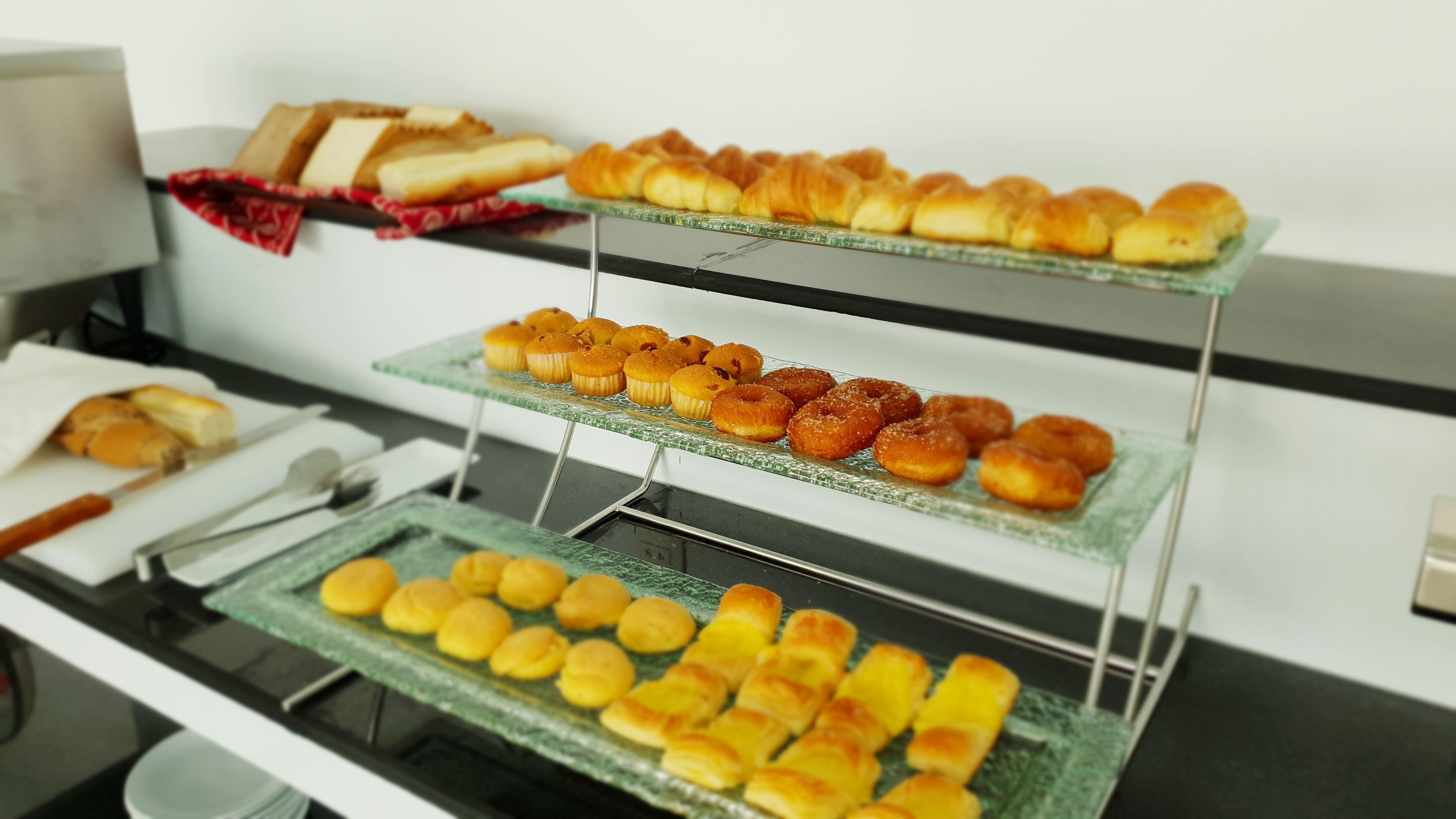 Een buffet met diverse gebakjes, brood en patisserie.