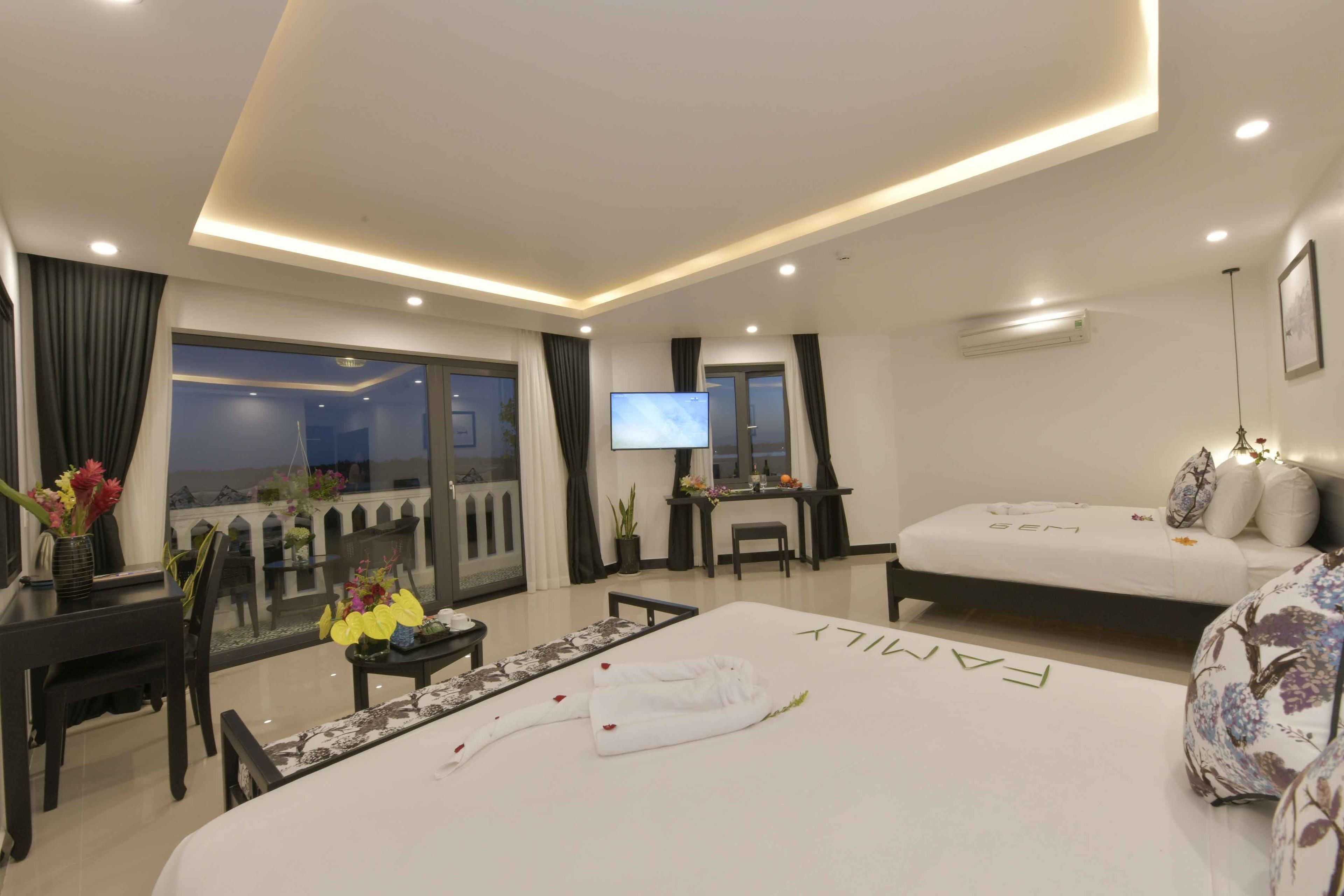 A modern hotel room with a balcony, a bed, a desk, and a TV.