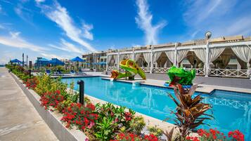 Relax by the pool surrounded by lush greenery and enjoy the view from the balcony.