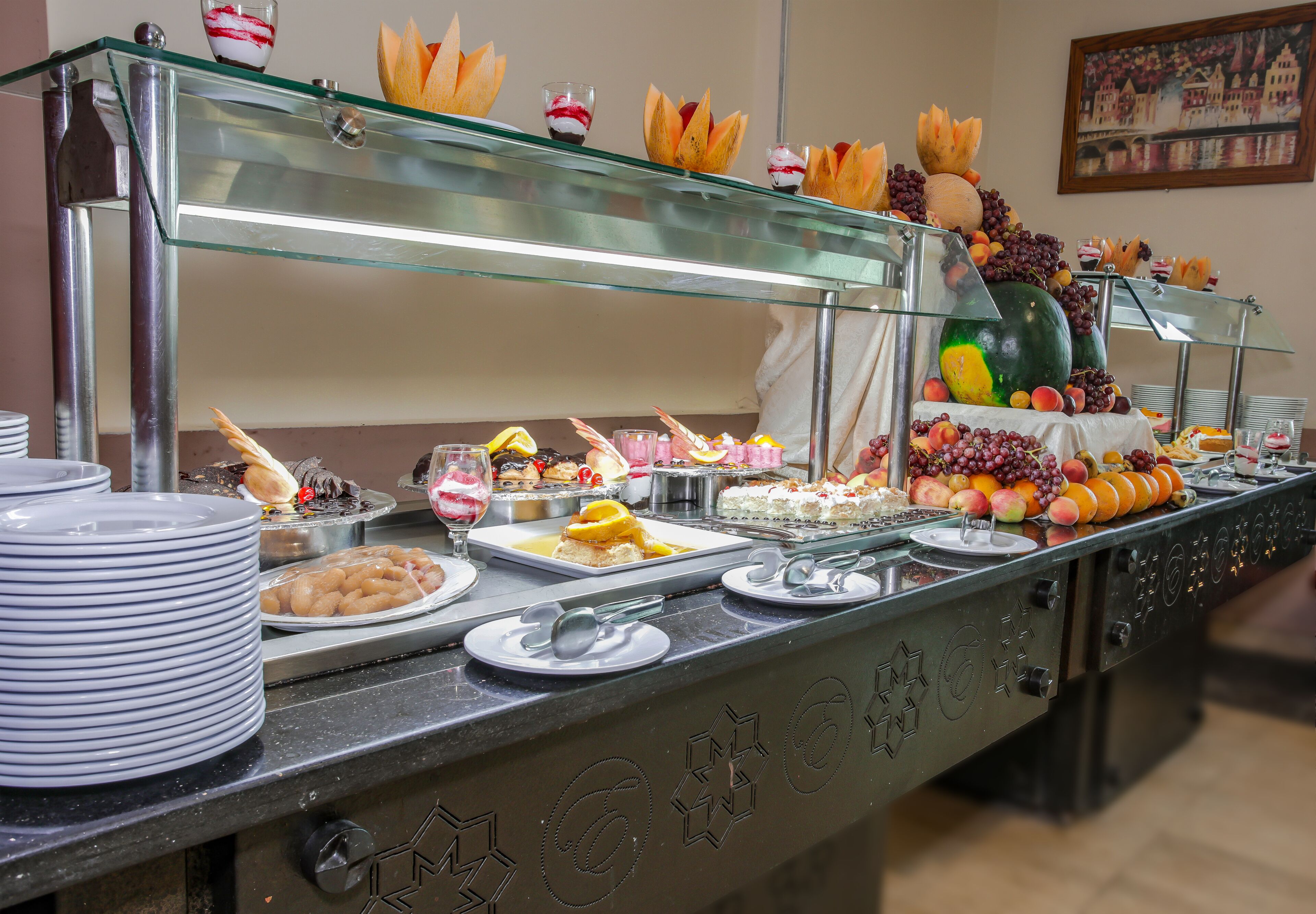 A buffet with various food items and a glass display case.