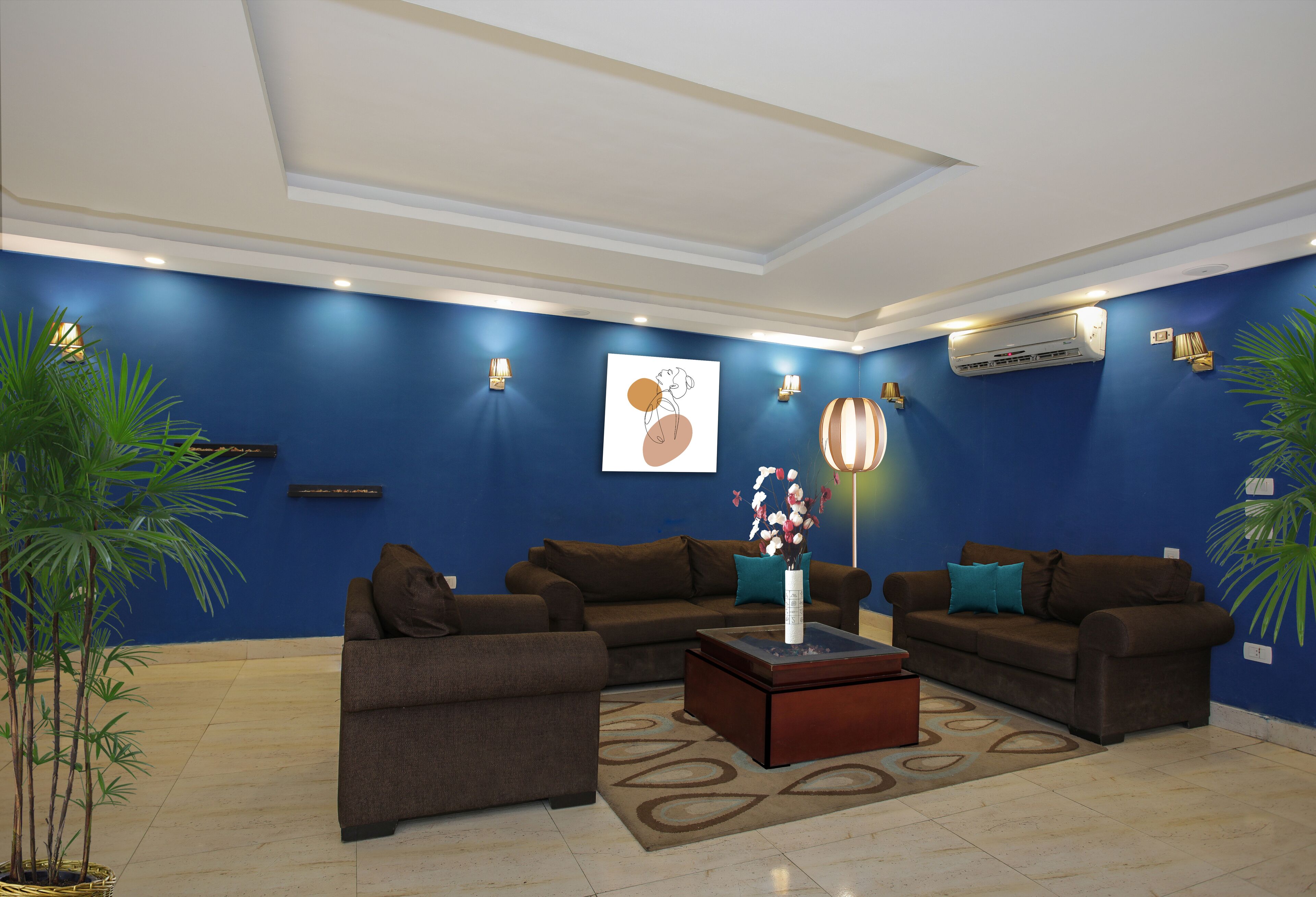 A modern living room with blue walls, brown sofas, a coffee table, and decorative lighting.