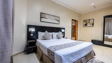 Habitación de hotel con una cama grande, una mesita de noche, un espejo y obras de arte en las paredes.