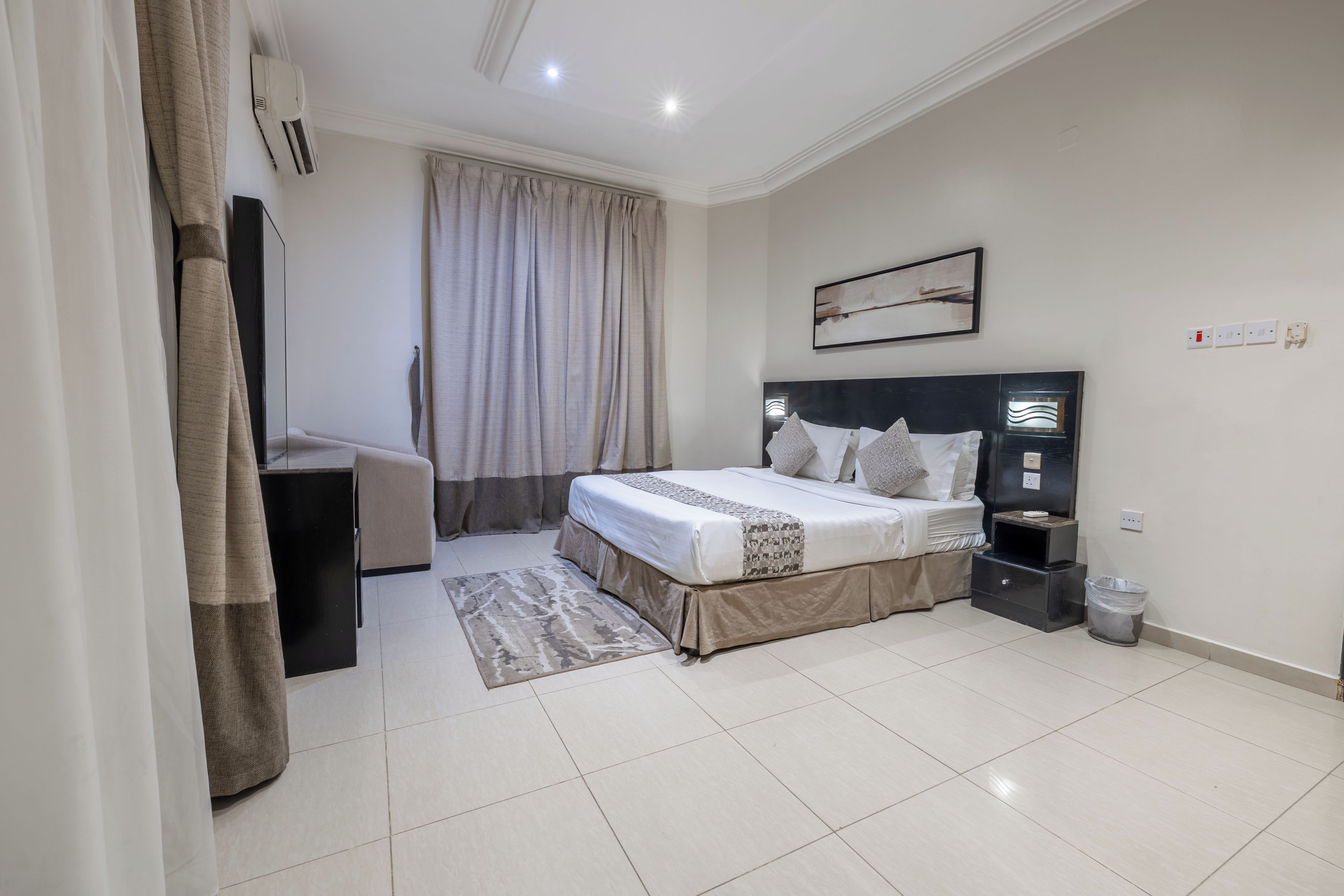 A modern bedroom with a bed, bedside table, and a desk.