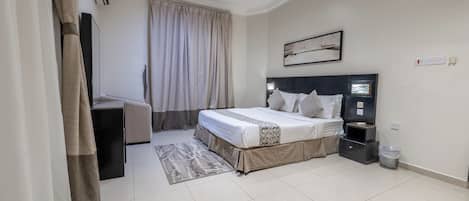 A modern bedroom with a bed, bedside table, and a desk.