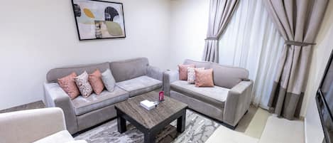 A modern living room with two sofas, a coffee table, and a telephone.