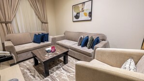 A living room with two sofas, a coffee table, and a patterned rug. - Nawara AL  ASKARY - Economic (Riyadh)