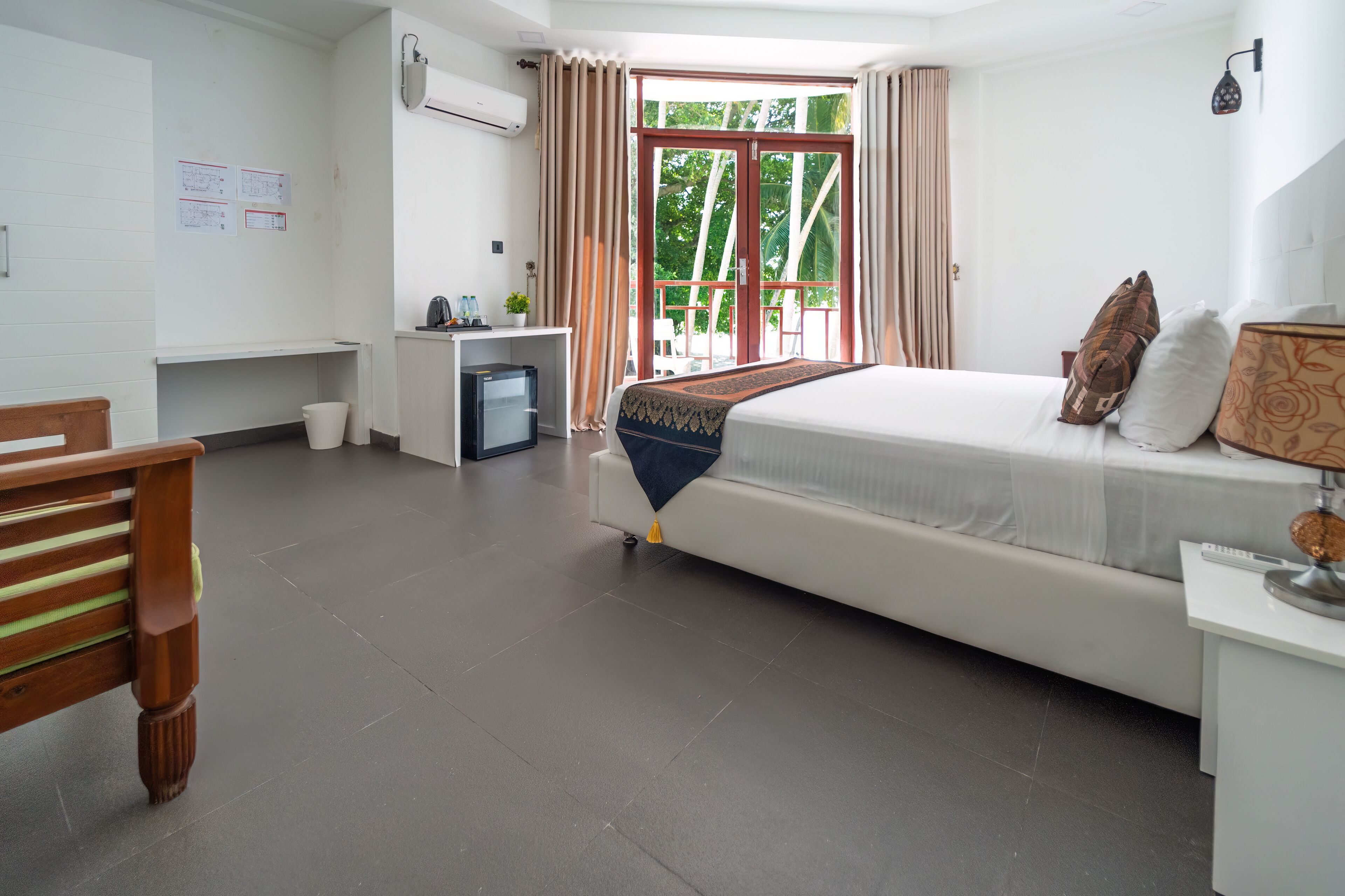 Habitación de hotel con cama, escritorio, silla y una pequeña cocina.