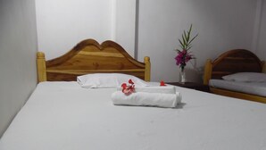 A neatly made bed with white linens and a floral arrangement. - Little Guest (Anuradhapura)