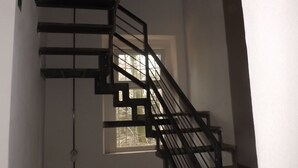 Eine Treppe mit Metallgeländer, die zu einer Zwischenebene führt.