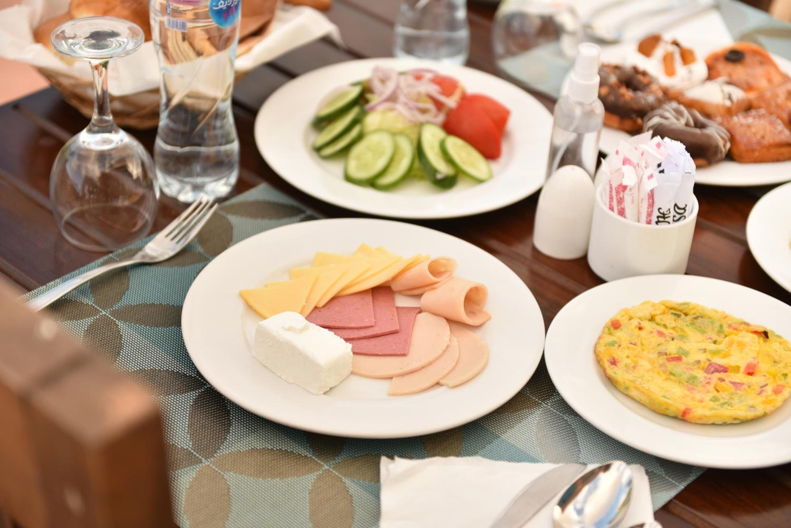 Une table avec des assiettes de nourriture, un verre d’eau et une bouteille d’eau.