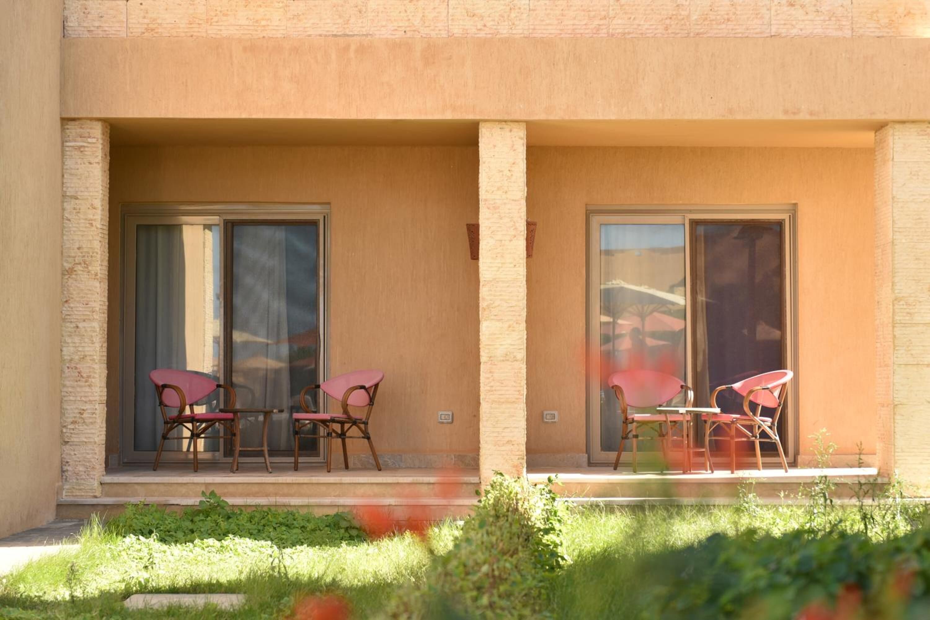 A building with two balconies, each with a table and chairs.