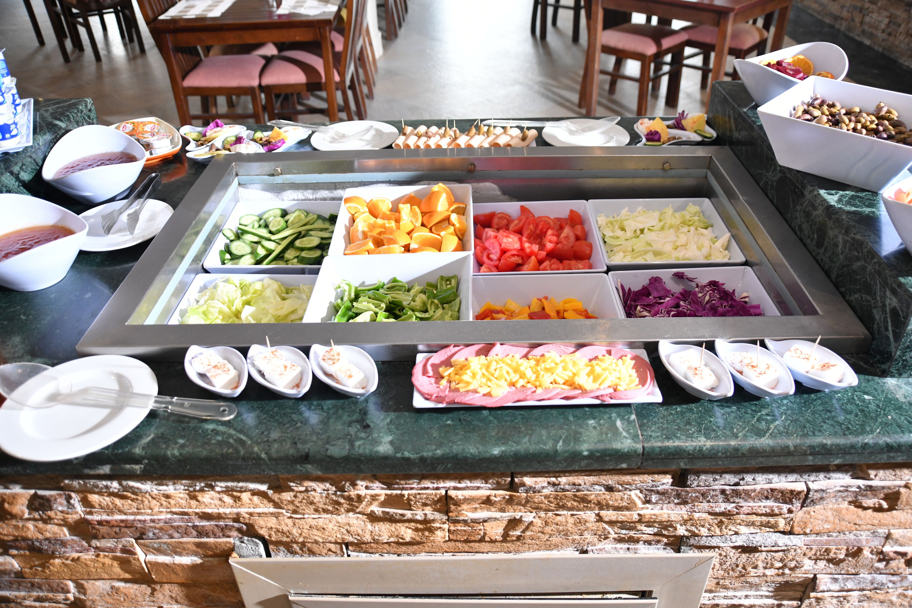 A buffet with various food items and bowls of sauces.