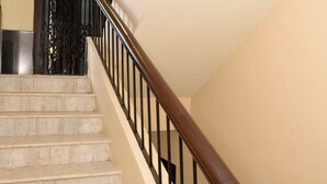 Una escalera con escalones de mármol y barandilla de madera.