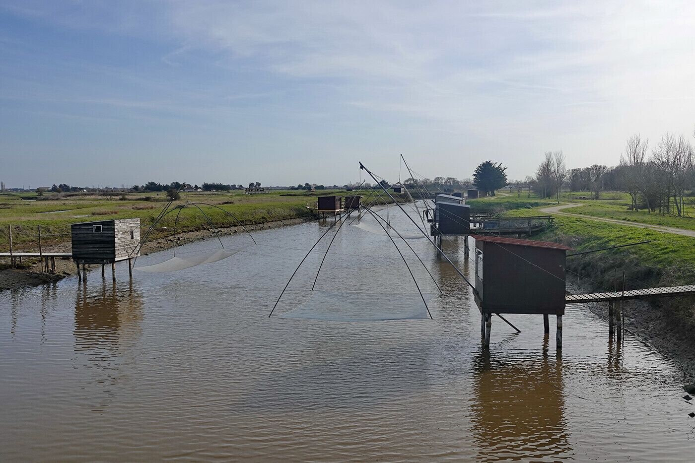 Une zone inondée où l’on trouve des structures en bois et du matériel de pêche.