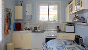 Una cucina compatta con lavastoviglie, fornelli e un piccolo frigorifero.