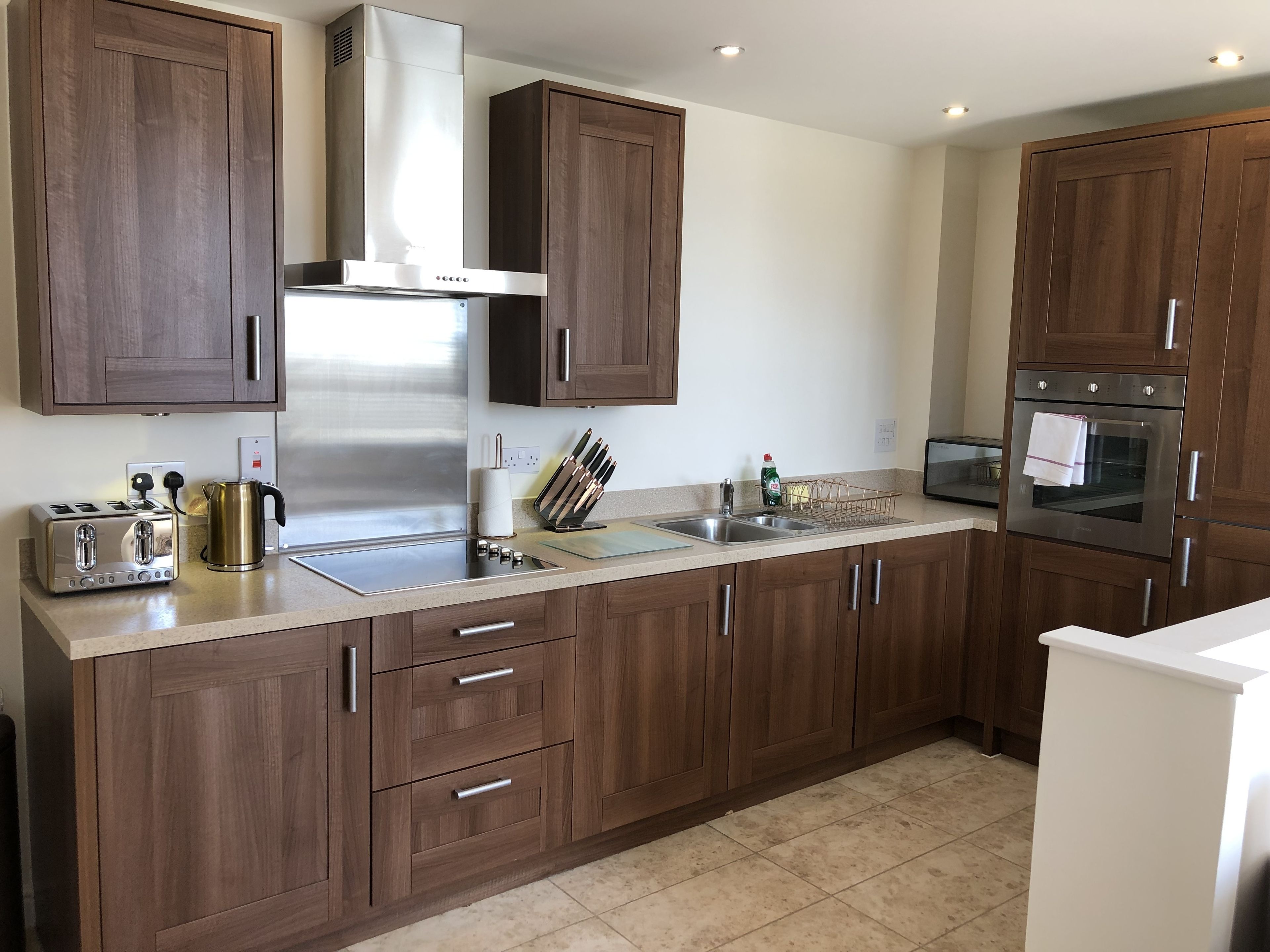 Una cocina moderna con armarios de madera, electrodomésticos de acero inoxidable y encimera de granito.