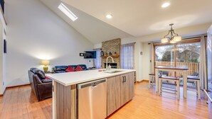 A modern kitchen with a dishwasher, a built-in oven, and a large window. - 5 Bedroom house with a Hot Tub and Home Theater! (Fort Collins)