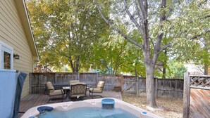 A backyard with a hot tub, outdoor furniture, and a wooden fence. - 5 Bedroom house with a Hot Tub and Home Theater! (Fort Collins)