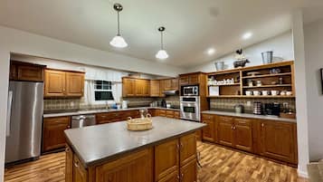 Une cuisine moderne avec des meubles en bois, des appareils en acier inoxydable et un îlot central.