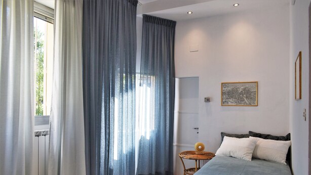 Une chambre à coucher avec un lit, une petite table ronde et une carte accrochée au mur.