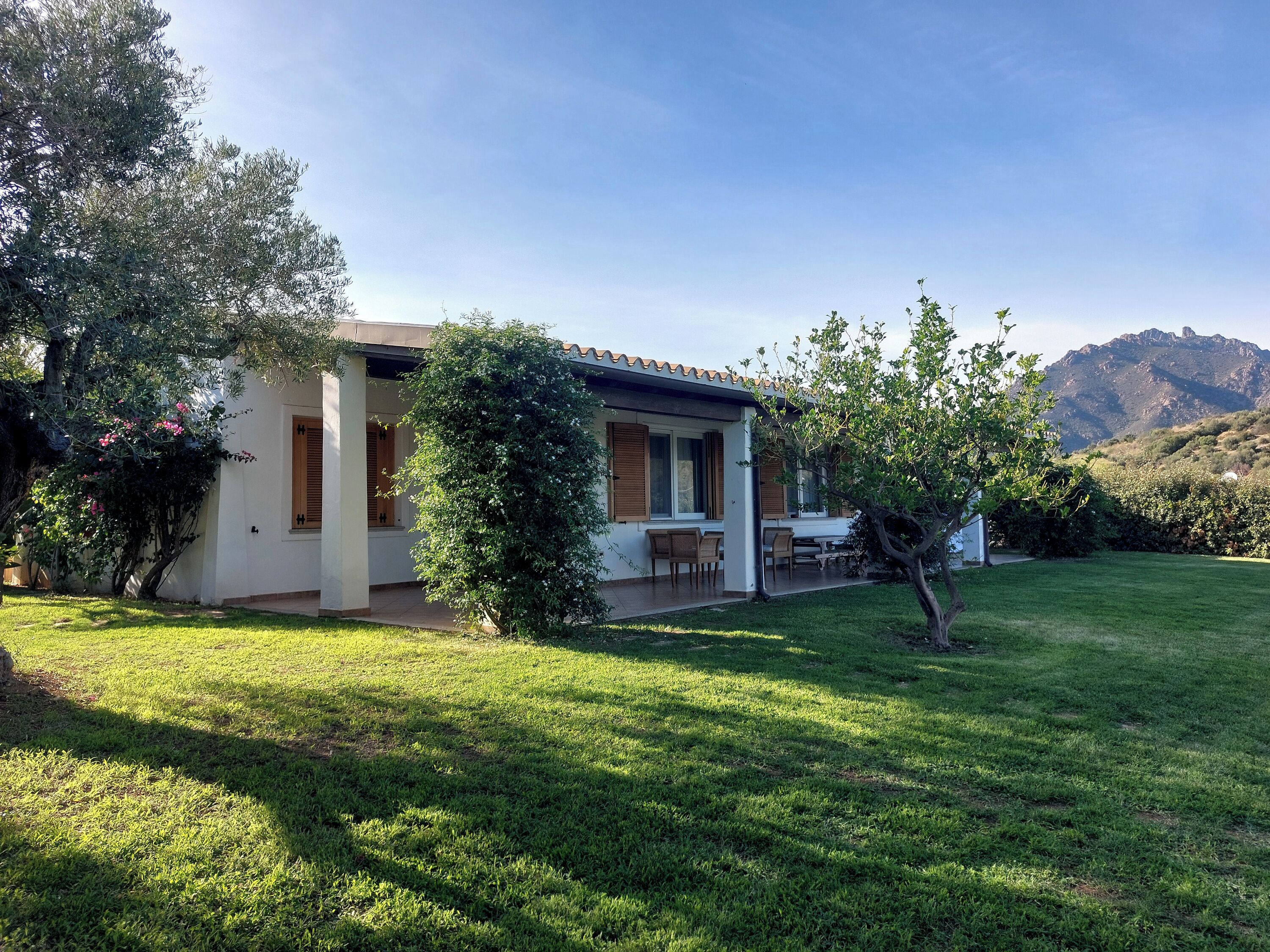 A house with a patio, a small garden, and a mountain view.