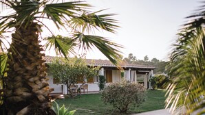A house with a tiled roof, a covered patio, and a well-maintained lawn. - Luxury Villa Maria - private pool (Tertenia)