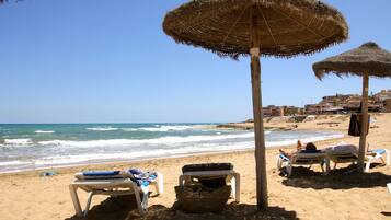 Accommodatie ligt op het strand, ligstoelen, strandlakens