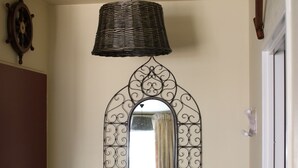 Une chambre avec un lit, une lampe suspendue, un miroir décoratif et un téléphone fixé au mur.