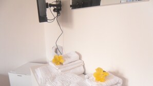 Ein Badezimmer mit einem weißen Waschbecken, einem Spiegel und Handtüchern mit gelben Blumen.