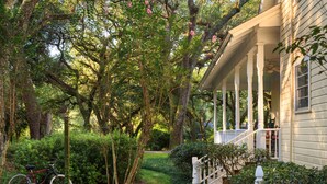A house with a porch, a bicycle, and a well-maintained garden. - Magnolia Springs B&B (Magnolia Springs)