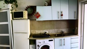 Cocina compacta con lavadora, microondas y lavaplatos.