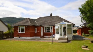 A red wooden house with a white porch and a covered outdoor area. - Cedar Cottage at Rashfield nr Dunoon-sleeps up to 6-Pet Friendly(1 max) (Dunoon)