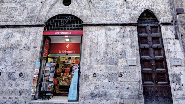 Ein Steinhaus mit einem Geschäftseingang, auf dem “la Feltrinelli” steht.