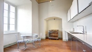 Eine Küche mit einem runden Tisch, Stühlen, einem Backofen und einem Spülbecken.