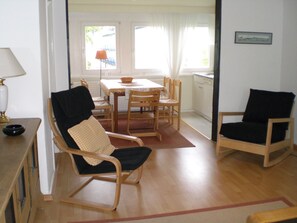 Una habitación con una mesa de comedor, sillas, un sofá y una zona de cocina.