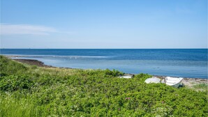 A coastal landscape with a clear sky, a bridge in the distance, and a boat on the shore. - 1 bedroom lovely home in Slagelse (Slagelse)