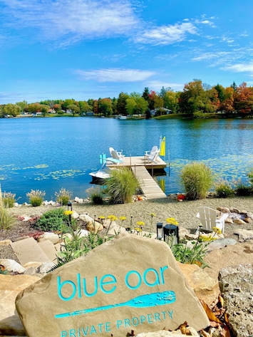 New waterfront pea gravel beach area with lounge area, floating dock and firepit