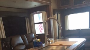 A kitchen with a granite countertop, a stainless steel sink, and dark cabinetry. - RELAX OFF THE BEATEN PATH! (Terlingua)