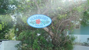 A sign for 'Hummingbird House' with a floral design, surrounded by dense foliage. -  PARADISE/ ask discount Sept/Oct- bonefishing, beaches/town/360 view, 98 5 stars (Georgetown)