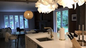 Una cocina moderna con una isla grande, un lavabo y una lámpara colgante.