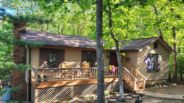 A cabin with a deck, a chimney, and a star decoration.