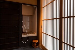 Et traditionelt japansk rum med en skydedør, en lille skammel og et vindue med lodrette lameller.