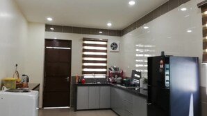 A compact kitchen with a refrigerator, sink, and cabinets. - KKP Homestay Alor Setar (Alor Setar)