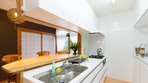 Una cucina moderna con un piano di lavoro in legno, lavello in acciaio inossidabile e piano cottura a gas.