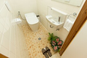 A bathroom with a toilet, sink, and shower. - South Window Onna-son (Onna)