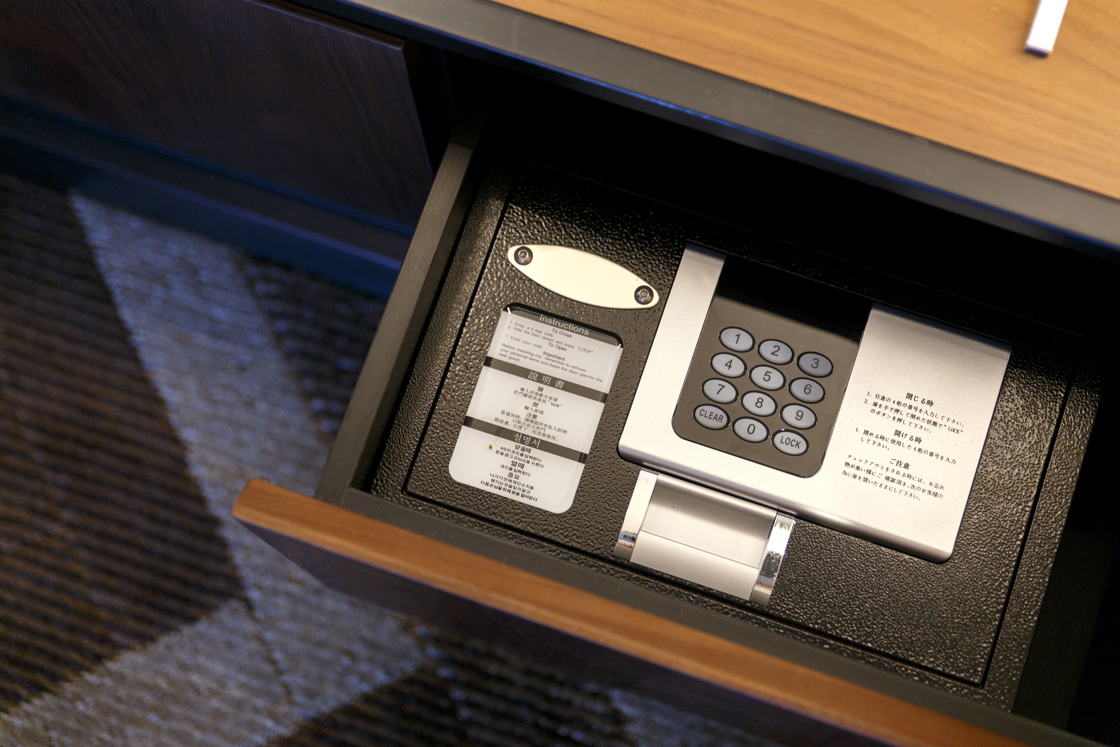 A hotel room's control panel with a keypad, a card reader, and a small booklet.